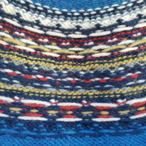 Inside of a yoked fair isle sweater showing yarn floats in primary colors