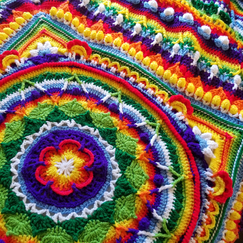 Mandala-style rainbow crochet afghan blanket in "Sophie's Universe" pattern